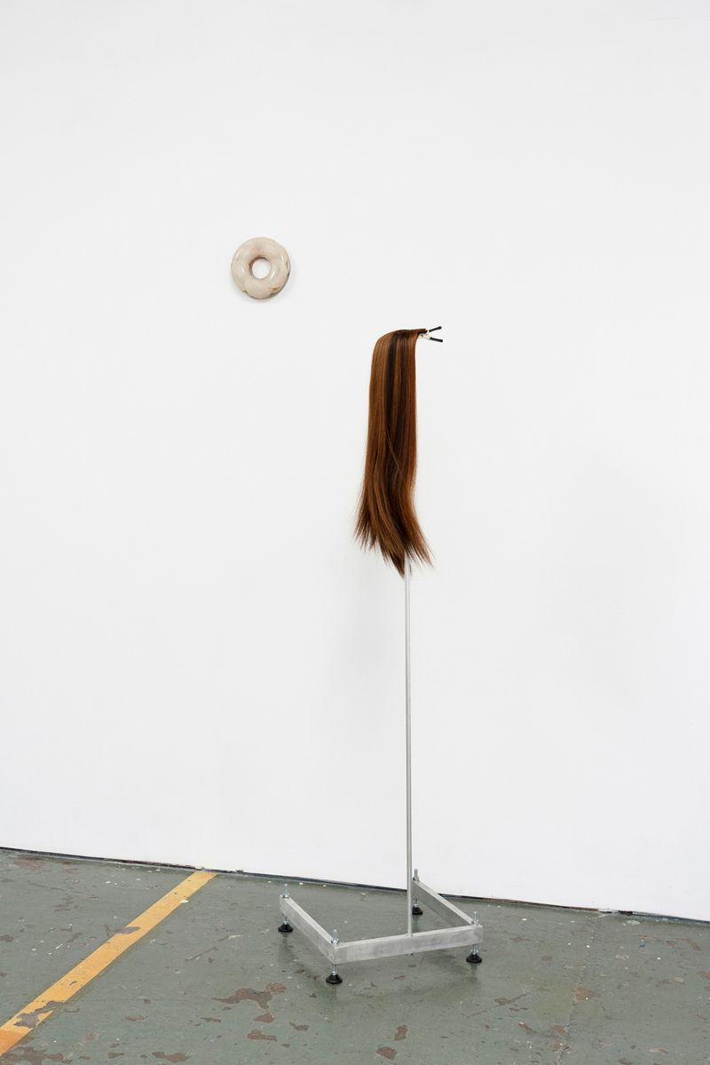 Install shot of Joanna Wierzbicka's work wig hanging on metal standing frame